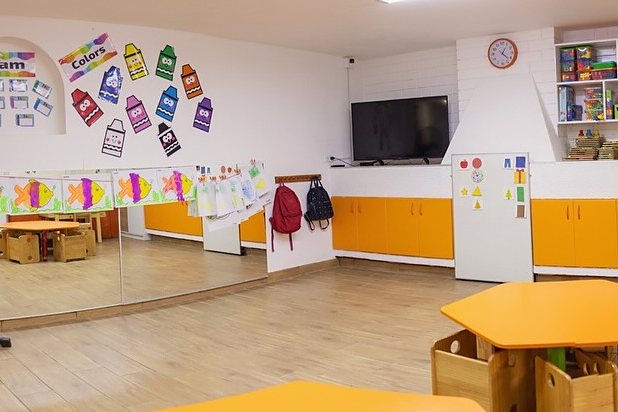 Orange Class: aula amplia con mesas naranjas y espejo