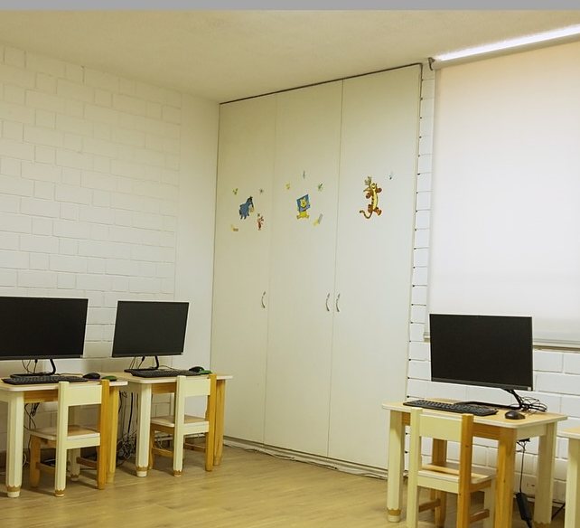 La salita de cómputo, con computadoras en mesas pequeñas